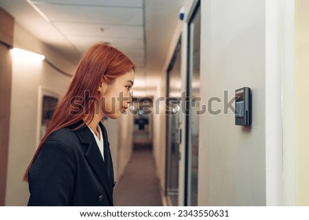 Businesswoman using face scanner to unlock door in office, Biometric admittance control device for security system. Royalty-Free Stock Photo #2343550631