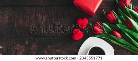 Bouquet of red tulips on a wooden background with a Cup of coffee. Spring flowers. Mother's day background. Horizontal wide photo subtitle, cover. copy-space