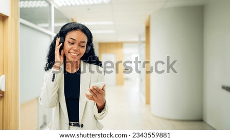 Shot of elegant young business woman smiling and  using mobile phone while walking, Copy space.