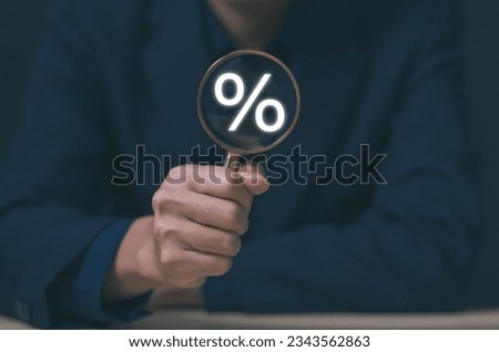 Businessman hand holding magnifying glass showing percentage sign business investment concept, increase stock profit, finance, marketing, sale, interest rate Better economy and discounts