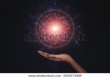 Woman holding illustration of bright star with zodiac wheel around it in open space, closeup