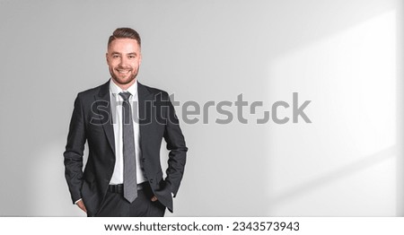 Successful businessman in black formal suit, hands in pocket and looking at the camera on empty copy space shadow background. Concept of leadership, business start up and profit Royalty-Free Stock Photo #2343573943