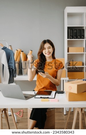 Young business owner woman prepare parcel box and standing check online orders for deliver to customer on tablet, laptop Shopping Online concept.
 Royalty-Free Stock Photo #2343580343