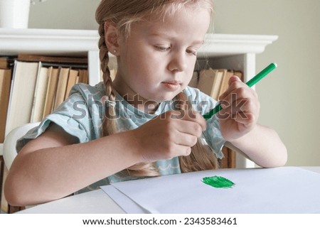 Cute child drawing a picture with colored felt-tip pens. Concept of hobby and education