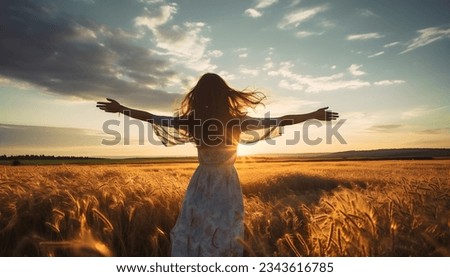 Girl at sunset with outstretched arms on a field with grain Royalty-Free Stock Photo #2343616785