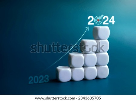 Increase rise up arrow on white blocks chart steps from year 2023 to 2024 with glowing year numbers on blue background. Trend, goal, profit, business growth process, and economic improvement concept.