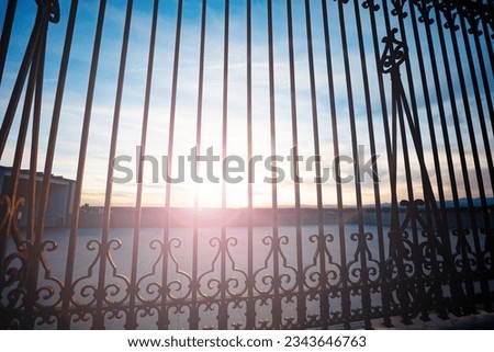 Entrance fence of Royal Palace of Madrid at Palacio Real square with subflare sunset light
