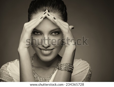 Beautiful woman in 20s framing her face with hands and smiling. Happiness concept.