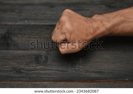 strong male fist on the background of wooden planks
