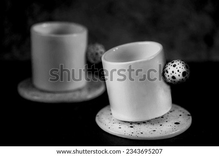 Beautiful handmade ceramic coffee cups on a black background, close up, black and white photography