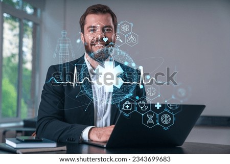 Smiling businessman in formal wear working on laptop at office workplace with smartphone and notebooks. Concept of successful business deal, agreement. Medical healthcare icons.