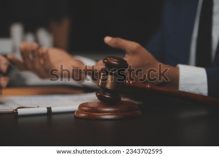 
Business and lawyers discussing contract papers with brass scale on desk in office. Law, legal services, advice, justice and law concept picture with film grain effect