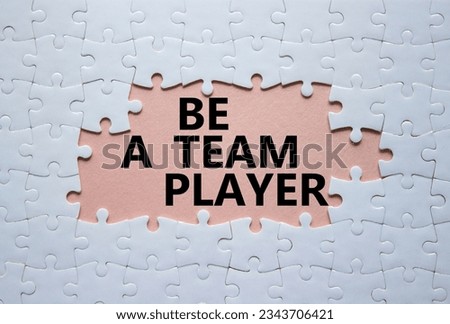 Be a team player symbol. Concept words Be a team player on white puzzle. Beautiful pink background. Business and Be a team player concept. Copy space