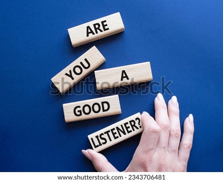 Listening skills symbol. Wooden blocks with words Are you a good Listener. Beautiful deep blue background. Businessman hand. Business and Are you a good Listener concept. Copy space.