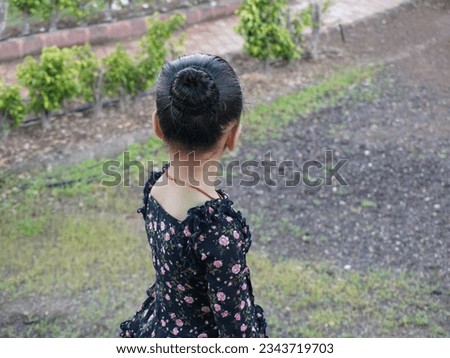Little girl on footpath and walking around it. Cute and nice light present filter effect on portrait camera photo. Clear subject focus behind defocus background. Kid wearing black color skirt.