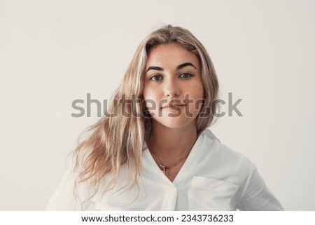 Close up overjoyed woman laughing, sitting on couch at home, head shot portrait young female chatting online with friends or relatives, looking at camera, having fun, making call or shooting video