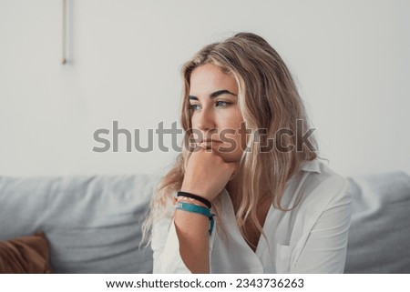 Side view young woman looking away at window sitting on couch at home. Frustrated confused female feels unhappy problem in personal life quarrel break up with boyfriend or unexpected pregnancy concept Royalty-Free Stock Photo #2343736263