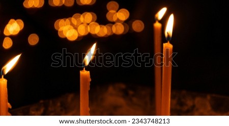 Burning candles in the church on a dark background. The idea of prayer and religion