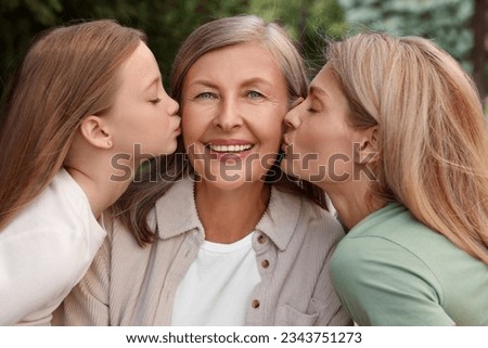 Three generations. Happy grandmother, her daughter and granddaughter outdoors