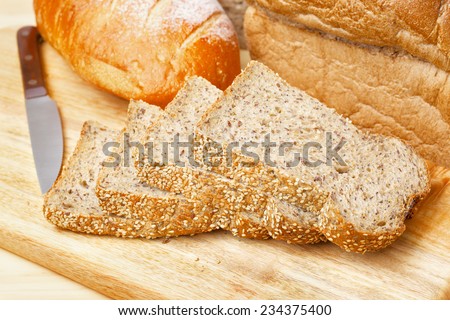 Cutted rye bread slices with seeds on a wooden board