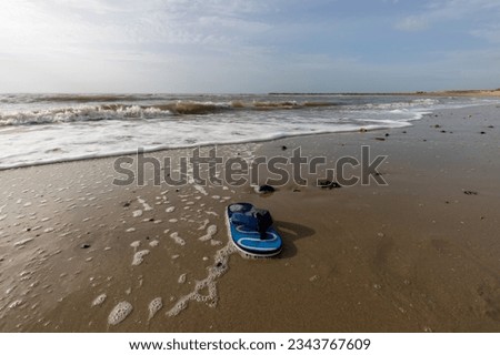 Blue sandal on the Beach with  seashell and bubble . Background with Sand Texture. Brown sand. Background from fine sand. Sand background