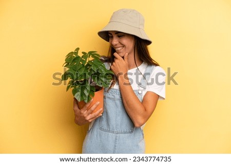 hispanic woman smiling with a happy, confident expression with hand on chin. gardering concept