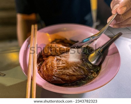 a picture of pouring sugar into a bowl of noodles