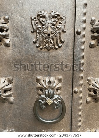 Old metal door knocker on a metal door. Retro vintage door knob. Close up. Copy space. Vertical frame.