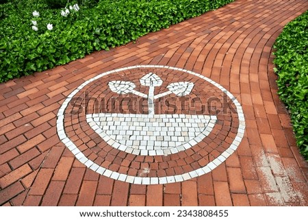 Red brick walkway with white circle with tree in the center in Germany.