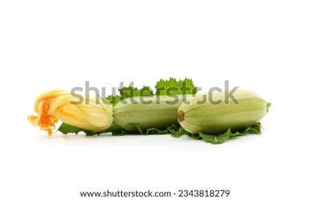 Two courgettes with leaves and flower isolated on a white background.