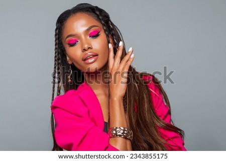 Fashion Portrait Black Woman in Pink clothes. Fashion Makeup curly hair and braids, lip gloss. Luxury Fashion model African American posing in studio, pink wall. Beautiful black woman looking down   