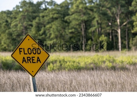 Piney Point, Maryland, USA A Flood Area road sign on a low lying road through marshland.