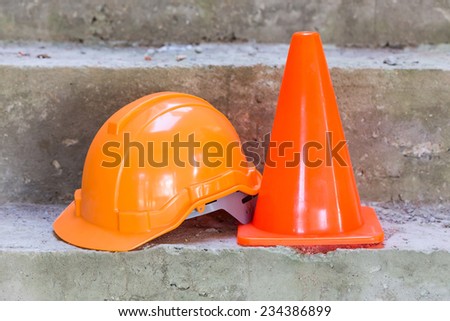 orange safety helmet and cone in construction site