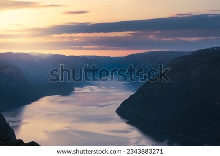 View of Lysefjorden fiord below cliff Preikestolen in Rogaland county, Norway. Tourist attraction called The Pulpit Rock during sunrise and golden hour in the summer of June 2023. Royalty-Free Stock Photo #2343883271