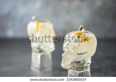 Boozy Corpse Reviver No 2 Cocktail with Gin and Lemon in Skull glass. Alcoholic drink and bar tools. Royalty-Free Stock Photo #2343885619