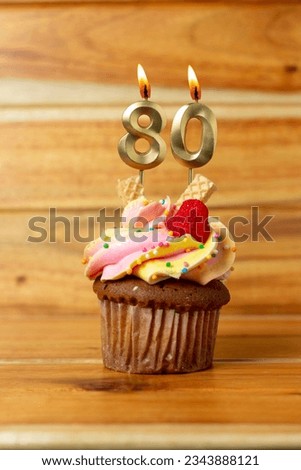 Golden birthday candle on wooden background - Birthday cupcake with numbered candle