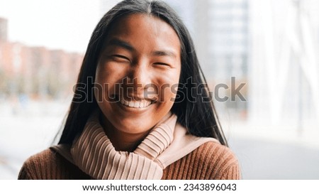 Authentic portrait of Asian woman smiling on camera with city background - Youth culture concept - Focus on eyes Royalty-Free Stock Photo #2343896043