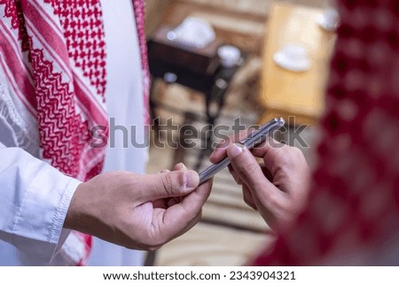 Arabian men holding their pen to sign the contract and have successful deal