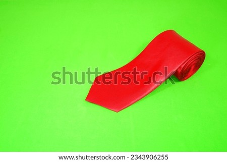 male fashion necktie rolled isolated on green background close up shot single object concept copy space for texting and commercial usage nobody in this scene 
