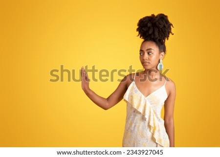 Unhappy confident offended millennial black lady in dress make stop gesture with hand, isolated on orange background, studio. Problems in work, human emotions, fight with harassment, sexism Royalty-Free Stock Photo #2343927045