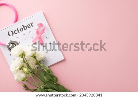 Health check reminder concept. Top view of October calendar, stethoscope, pink ribbon, and eustoma flowers on soft pink background, perfect for health campaigns or medical advertisements