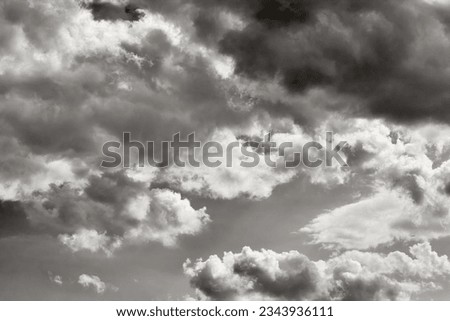 Gray sky with white clouds. Monochrome sky. Black and white photo.