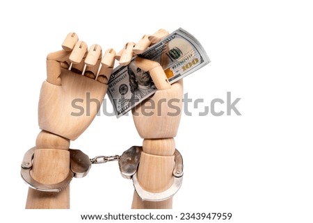 bail reform concept with wooden hands handcuffed holding 100 dollar bills cash Royalty-Free Stock Photo #2343947959
