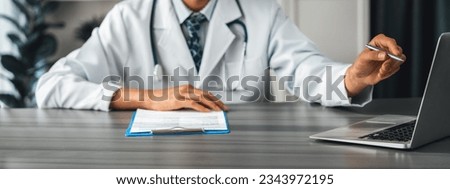 Doctor carefully review detailed medical report with laptop and diagnosing illness for effective healthcare treatment plan for patient in doctor office. Professional medical evaluation. Neoteric Royalty-Free Stock Photo #2343972195