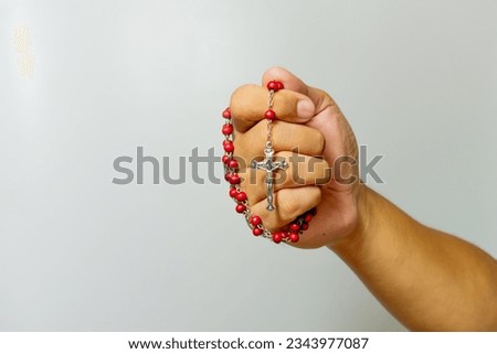 Male Hands holding rosary beads and cross

