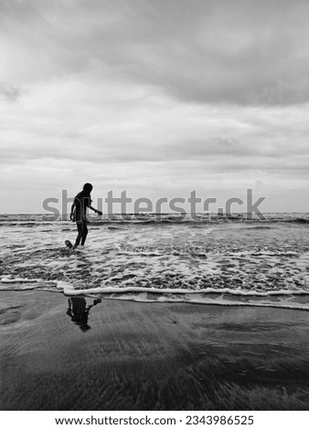 A young girl playing in the sea, standing on the sand, by the sea, lonely. For illustration. There is a background of the sea and sky.