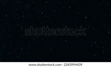 Glowing particles. Sparkles texture. Shimmer rain. Blur blue color light dust flakes floating on dark black free space abstract background.