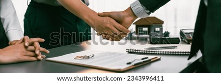 Client and real estate agent shake hand after signing house loan contract. Successful agreement for new home purchase sealing deal by handshaking. Housing business and finance panorama image. Prodigy