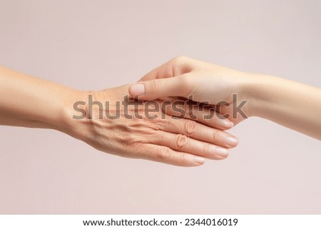 Young and old hand touching each other, Conceptual image of skin aging and beauty Royalty-Free Stock Photo #2344016019