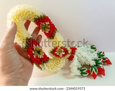 Garland of fake jasmine flowers and roses hanging with rose buds and gardenias. White background.